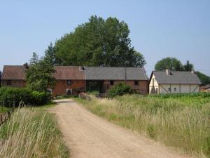 a dirt road in front of a group of buildings at De Kleen Meulen - max 6pers in Lummen