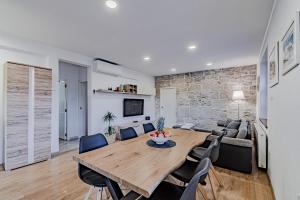 a dining room and living room with a wooden table and chairs at Stella apartment in Korčula