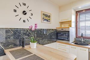 a kitchen with a clock on the wall at Stella apartment in Korčula