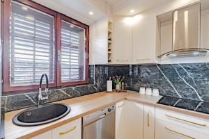 a kitchen with white cabinets and a sink and a window at Stella apartment in Korčula +22 photos