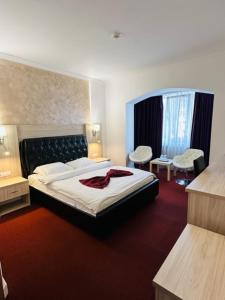 een hotelkamer met een bed en twee stoelen bij Hotel Bulevard Prestige in Slatina
