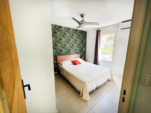 - une chambre avec un lit et un ventilateur de plafond dans l'établissement Le Pétrel Bleu - Appartement sur la plage des Tortues à Saint-Leu, à Saint-Leu