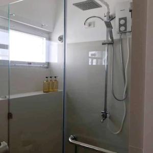a shower with a glass door in a bathroom at Cozy Holiday Home at Batulao Artscapes 2Br brand new fully airconditioned in Calo