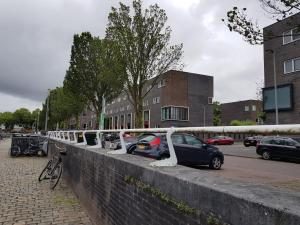 uma fila de carros estacionados ao lado de uma parede em Boathotel Rotterdam Seven em Roterdã