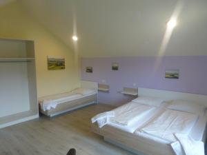 two beds in a room with purple walls at ROSSLWIRT-Rast in Strass im Attergau