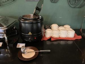 a group of white cups and a pot on a counter at Avatar Railay in Railay Beach
