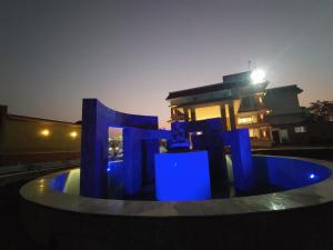 a blue fountain in front of a building at night at Flamingo Club and Resort Una 3 Km Away from Diu Check Post in Diu