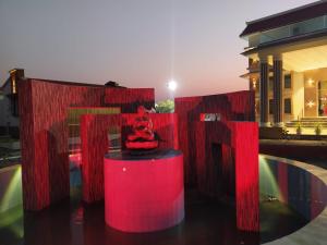 a red sculpture on a table in front of a building at Flamingo Club and Resort Una 3 Km Away from Diu Check Post in Diu