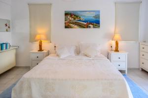 Punta的住宿－View Villas，一间卧室配有一张带两盏灯的大型白色床。