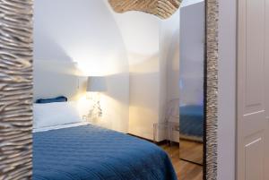 - une chambre avec un lit bleu et un miroir dans l'établissement Stella Maris suite relax, à Termoli