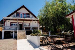 a house with a patio and a table in front of it at Vila Bucuria Corbu in Corbu