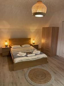 a bedroom with a bed with two night stands and two lamps at Vila Bucuria Corbu in Corbu