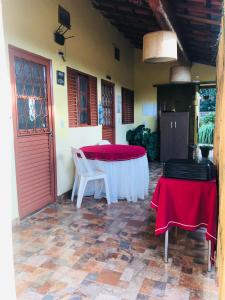 Zimmer mit einem Tisch mit roten und weißen Tischdecken in der Unterkunft Pousada Recanto das Flores in Aiuruoca