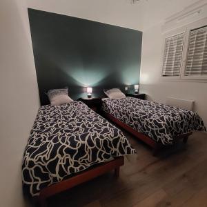 um quarto com 2 camas e uma parede preta em La Campagne D'ORNANS 