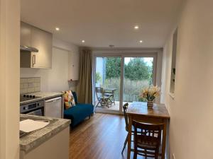 a kitchen and living room with a table and a couch at Ashcroft Apartment - Small Home Away From Home in Ashburton