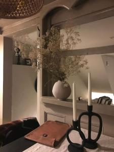 una mesa con dos velas y un jarrón con flores en Hook House, en Moretonhampstead