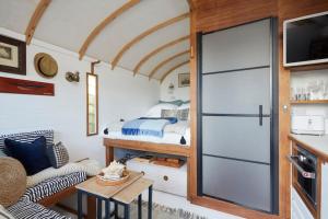 a tiny house with a bed and a sliding door at The Cabana - a romantic seaside getaway and garden in Ryde