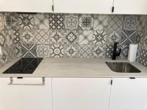 un bancone della cucina con lavandino e parete piastrellata di Casita Puig Campana Finestrat a Finestrat