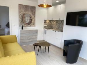 uma sala de estar com um sofá amarelo e uma cozinha em Casita Puig Campana Finestrat em Finestrat