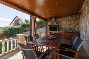 a wooden table and chairs on a balcony with a fireplace at Casa Lourdes in Barcelona