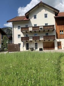 a large white house with a field in front of it at Ferienwohnung "Beim Dôneslar" in Bad Oberdorf