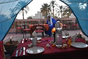 a woman sitting at a table in a tent at Prends Ton Temps in Zagora