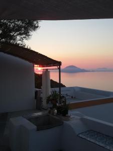 una casa con bañera y vistas a la puesta de sol. en Alicudi Giardino dei Carrubi- al gradino 365, en Alicudi