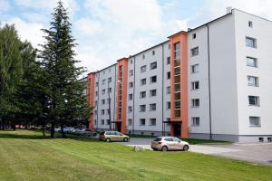 a row of buildings with cars parked in a park at Cozy apartment near Lõunakeskus with home cinema in Tartu