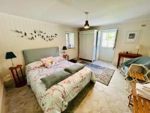 ein Schlafzimmer mit einem Bett mit Vögeln an der Wand in der Unterkunft Le logis de Lasteyrie in La Rochebeaucourt-et-Argentine