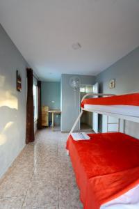 Pokój z 2 łóżkami piętrowymi i czerwoną kanapą w obiekcie Wing Camp w mieście Cabarete