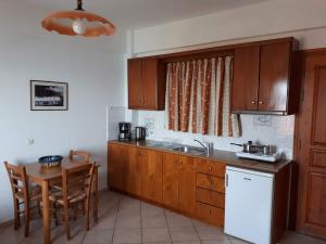 a kitchen with wooden cabinets and a table and a sink at Thalina Hotel in Marathokampos