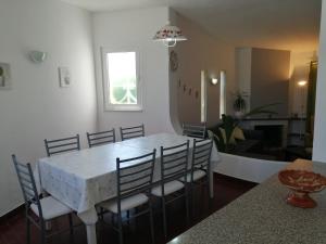 una sala da pranzo con tavolo e sedie bianchi di Oura Villa V5 ad Albufeira