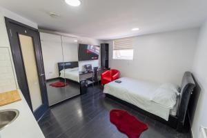 a bedroom with a bed and a bathroom with a sink at Lovely studio close to University of Birmingham! in Birmingham