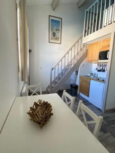 a kitchen with a white table and a staircase at Les Remparts in Saint-Martin-de-Ré