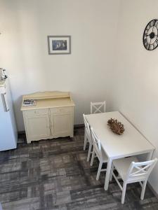 a kitchen with a white table and a table and chairs at Les Remparts in Saint-Martin-de-Ré