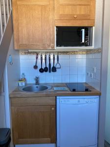 a small kitchen with a sink and a microwave at Les Remparts in Saint-Martin-de-Ré