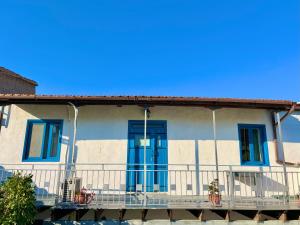 a house with blue doors and a balcony at Cottage Apartment Othellos in Kalavasos