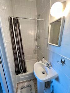 Cottage Apartment Othellos في كالافاسوس: حمام مع حوض ودش مع مرآة