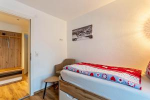 ein Schlafzimmer mit einem Bett mit einer roten Decke darauf in der Unterkunft Bergwelt A2 in Niederau