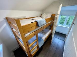 a couple of bunk beds in a tiny house at Cosy Coastal 2-Bedroom Cottage with Hot Tub and Log Burner in West Mersea