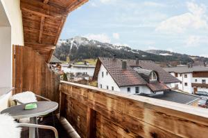 a balcony with a table and a view of a city at Bergwelt B in Niederau