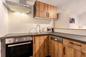 - une cuisine avec des placards en bois et un évier dans l'établissement Bergwelt B, à Niederau