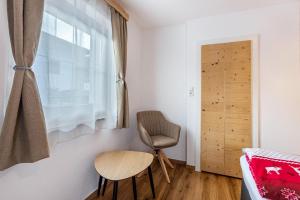 ein kleines Zimmer mit einem Stuhl und einem Fenster in der Unterkunft Bergwelt A1 in Niederau