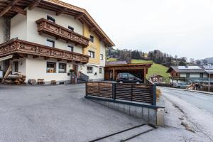 ein Haus mit einem Tor vor einer Straße in der Unterkunft Bergwelt C in Niederau