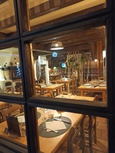 un reflet d'une salle à manger avec des tables dans une fenêtre dans l'établissement Chalet Appart'Hôtel l'Eau Vive, à Saint-Nicolas-la-Chapelle