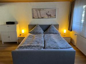 Cette chambre comprend un lit avec deux lampes et un cerf sur le mur. dans l'établissement Bergmannsruh, à Clausthal-Zellerfeld