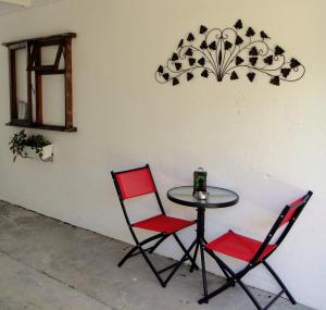 a table with two chairs and a table with a candle on it at Our Nest Guest House in Kleinmond