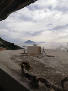 un tavolo seduto sopra un tetto con vista sull'oceano di Alicudi Giardino dei Carrubi- al gradino 365 ad Alicudi