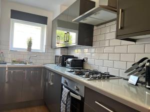 Il comprend une cuisine équipée d'une cuisinière. - un four supérieur à côté d'un évier dans l'établissement Beautiful 4-Bed House in Lincoln- close to Centre, à Lincoln