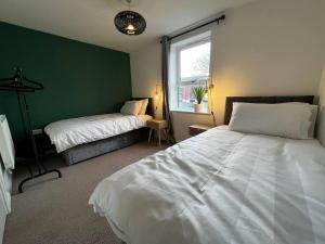 sypialnia z 2 łóżkami i oknem w obiekcie Beautiful 4-Bed House in Lincoln- close to Centre w mieście Lincoln